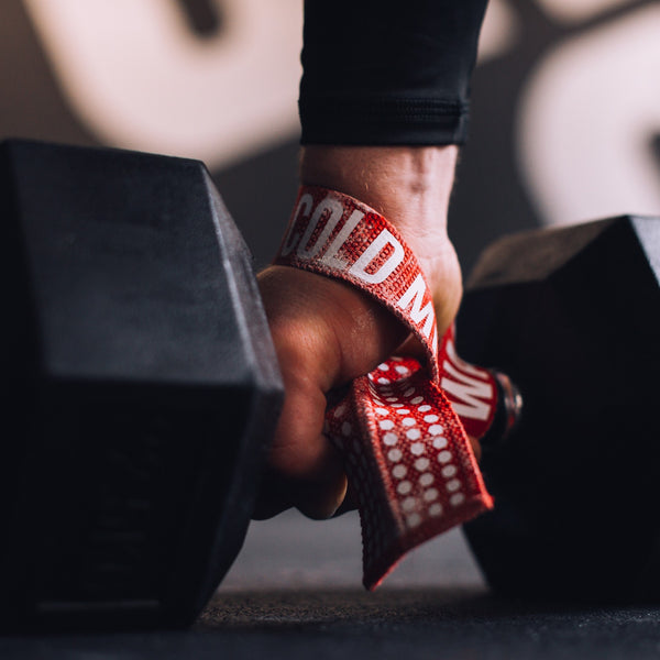 Man lifts a dumbbell using Red Weight Lifting Wrist Straps V1