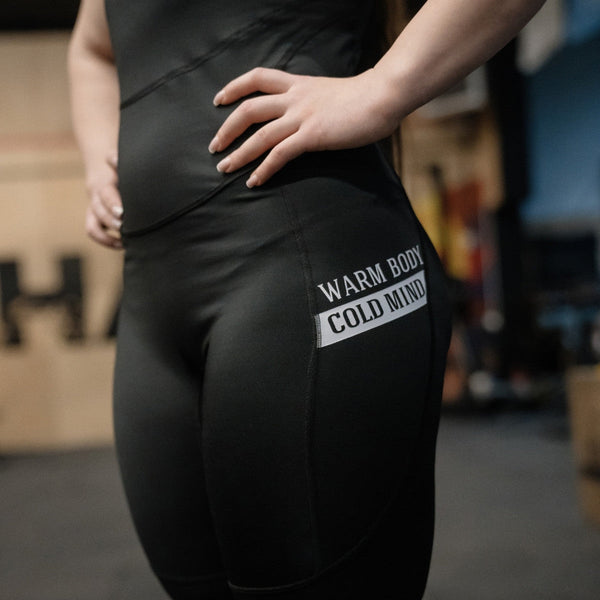Woman in WOMEN'S WEIGHTLIFTING COMPRESSION SINGLET S-4 standing in a gym (close-up view) - Warm Body Cold Mind